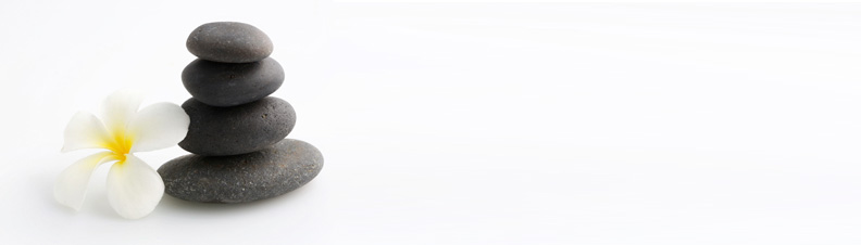 Calming image of a grey stone inukshuk and white flower on a white background